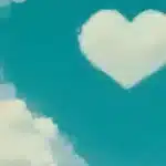 Nuage blanc en forme de cœur sur ciel turquoise avec autres nuages blancs, photographie aux tons turquoise et crème.